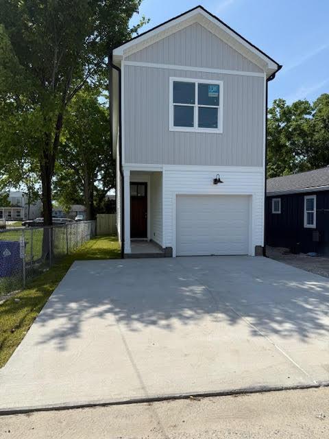 view of front of property with a garage, fence, and driveway