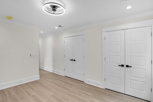 unfurnished bedroom featuring light wood-style flooring, baseboards, recessed lighting, and crown molding