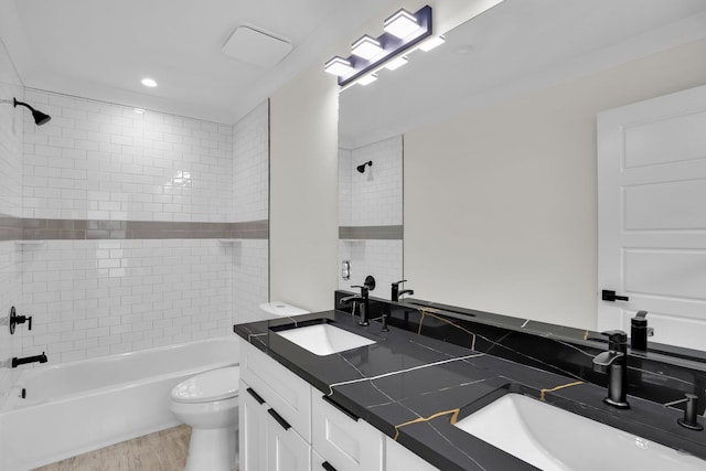 bathroom featuring toilet, bathtub / shower combination, double vanity, and wood finished floors