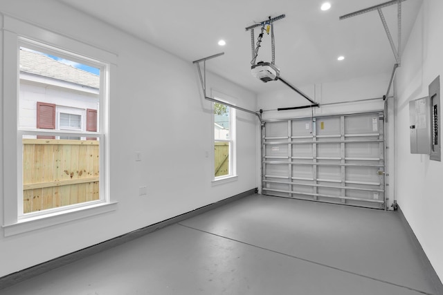 garage featuring a garage door opener, recessed lighting, and electric panel
