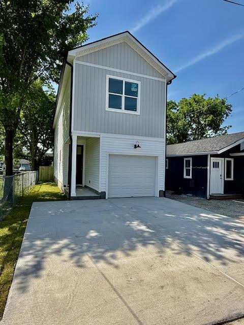 view of front facade featuring fence, an attached garage, and concrete driveway