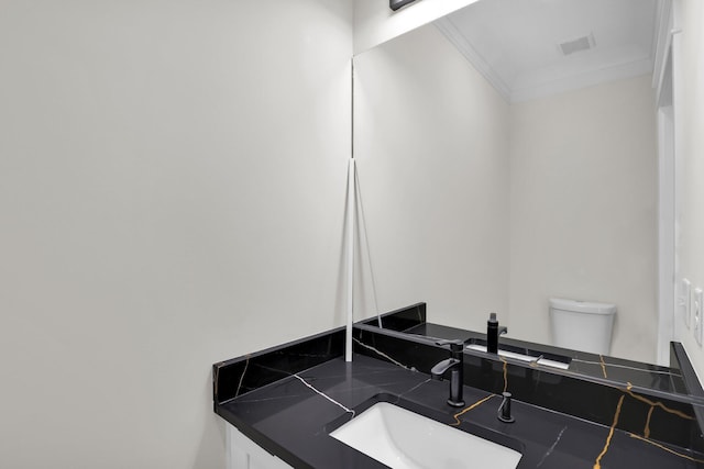 bathroom featuring vanity, toilet, and ornamental molding