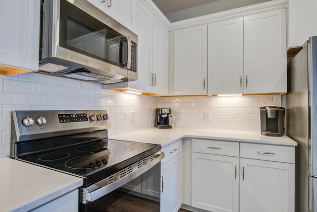 kitchen featuring decorative backsplash, appliances with stainless steel finishes, white cabinets, and light countertops