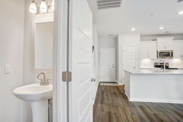 kitchen featuring visible vents, light countertops, appliances with stainless steel finishes, backsplash, and dark wood-style floors