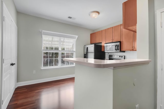 1604 Basildon Rd, Mount Pleasant, SC 29466 - kitchen with stainless steel appliances, dark wood finished floors, a peninsula, decorative backsplash, and light countertops