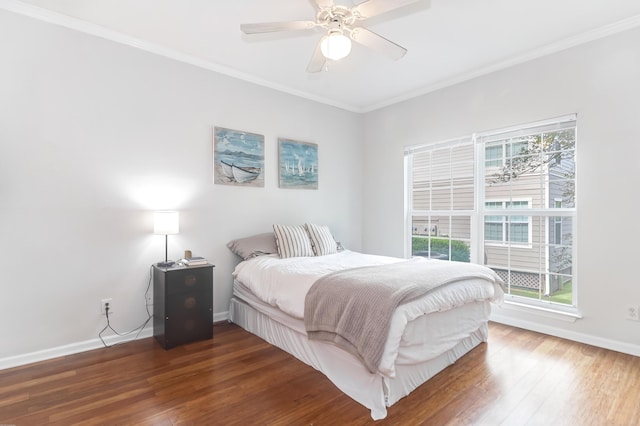 bedroom with baseboards, a ceiling fan, crown molding, and wood finished floors