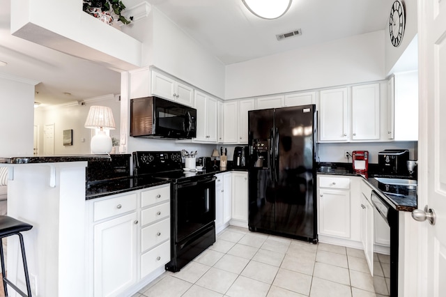 kitchen with visible vents, white cabinets, dark stone countertops, and black appliances