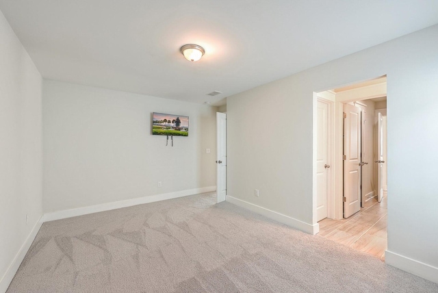 unfurnished room featuring light colored carpet