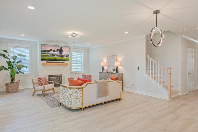 living room with crown molding, light wood-type flooring, and a wealth of natural light