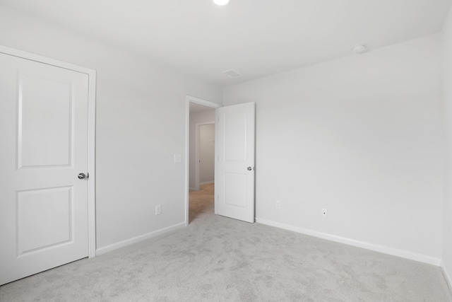 unfurnished bedroom featuring light carpet