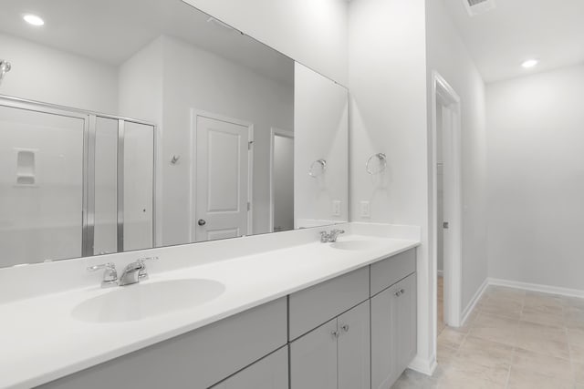 bathroom featuring vanity, tile patterned flooring, and a shower with door