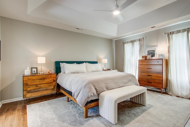 1081 Groves Manor Ct, Mount Pleasant, SC 29464 - bedroom featuring a tray ceiling, wood finished floors, ceiling fan, and baseboards
