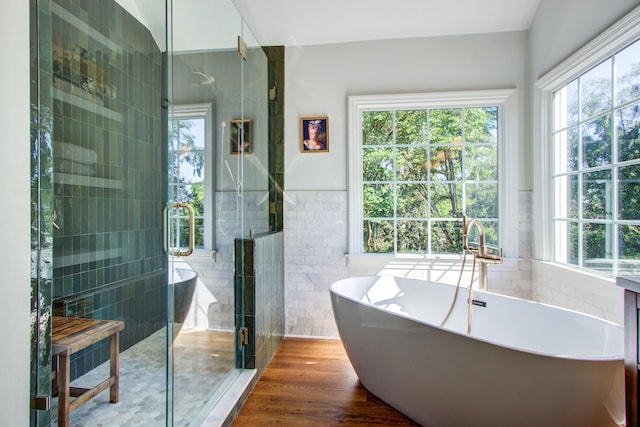 1081 Groves Manor Ct, Mount Pleasant, SC 29464 - bathroom featuring tile walls, a shower stall, a soaking tub, wainscoting, and wood finished floors