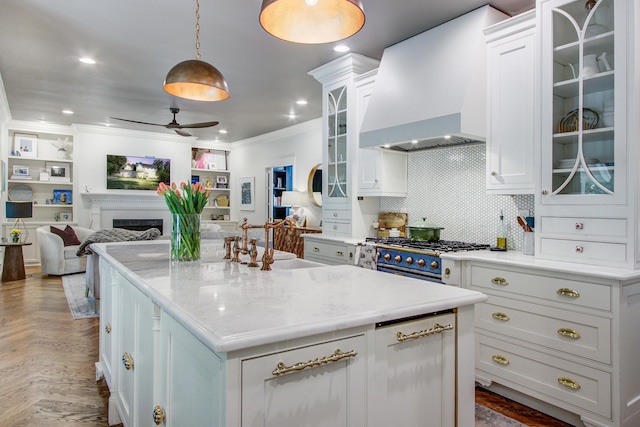 1081 Groves Manor Ct, Mount Pleasant, SC 29464 - kitchen with wall chimney exhaust hood, ornamental molding, white cabinets, ceiling fan, and a kitchen island