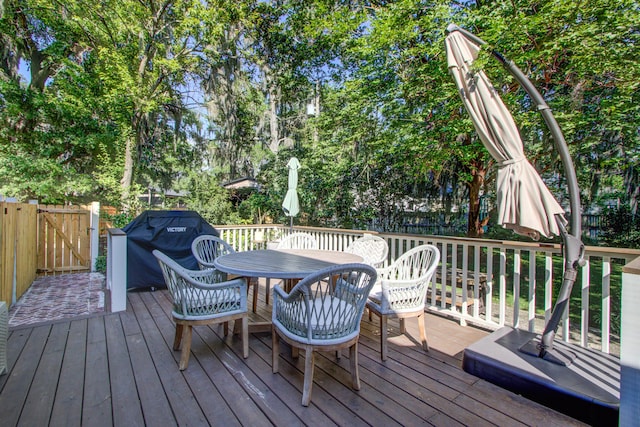1081 Groves Manor Ct, Mount Pleasant, SC 29464 - wooden deck with a fenced backyard, outdoor dining space, and view of wooded area