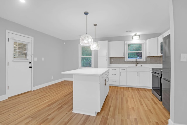 1873 Hazelwood Dr, Charleston, SC 29407 - kitchen featuring light countertops, light wood-type flooring, electric stove, a sink, and white cabinets
