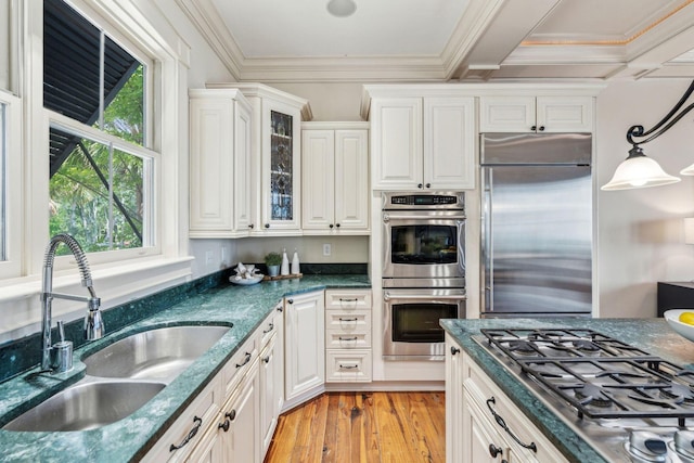 104 Beach St, Mount Pleasant, SC 29464 - kitchen with appliances with stainless steel finishes, a sink, light wood finished floors, glass insert cabinets, and white cabinets