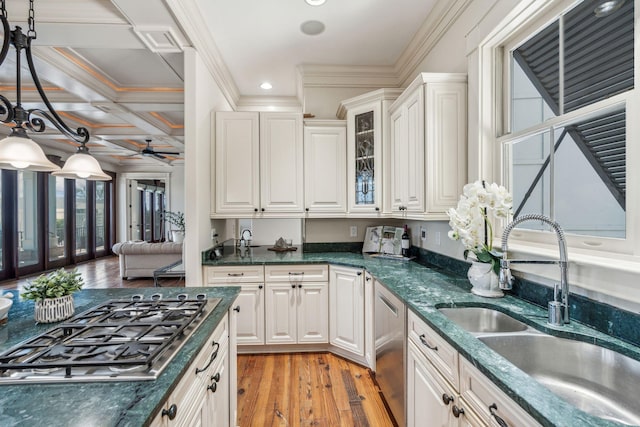 104 Beach St, Mount Pleasant, SC 29464 - kitchen featuring appliances with stainless steel finishes, a sink, light wood-style floors, glass insert cabinets, and hanging light fixtures
