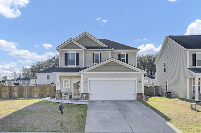 view of front of property featuring central AC unit, fence, driveway, a front lawn, and stone siding