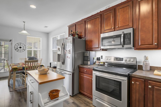 kitchen with stainless steel appliances, dark wood-type flooring, pendant lighting, and visible vents