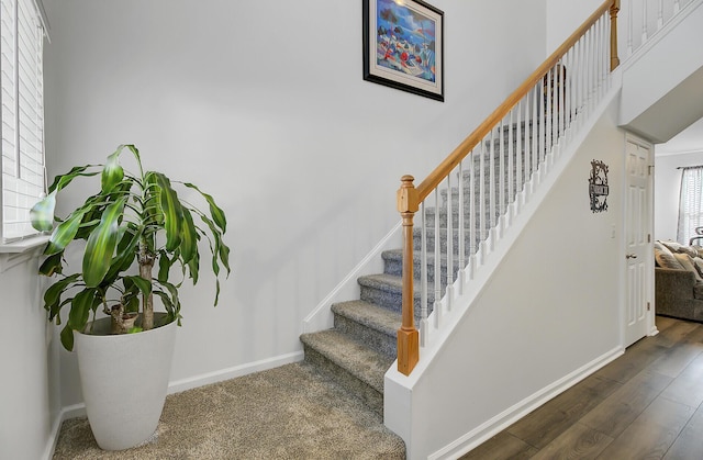 staircase featuring baseboards and wood finished floors