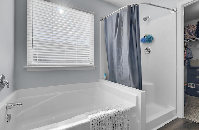 full bathroom featuring a bath and a stall shower