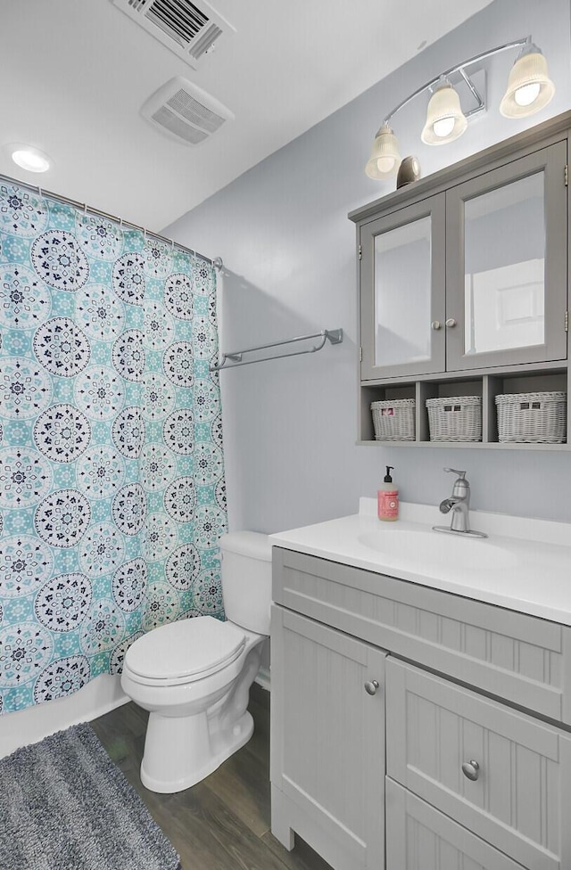 full bath with a shower with shower curtain, visible vents, toilet, and vanity