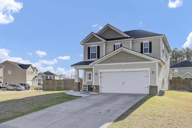 craftsman house featuring a front lawn, stone siding, fence, a residential view, and concrete driveway