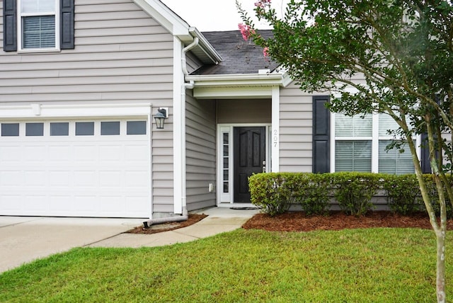 property entrance with a garage and a lawn