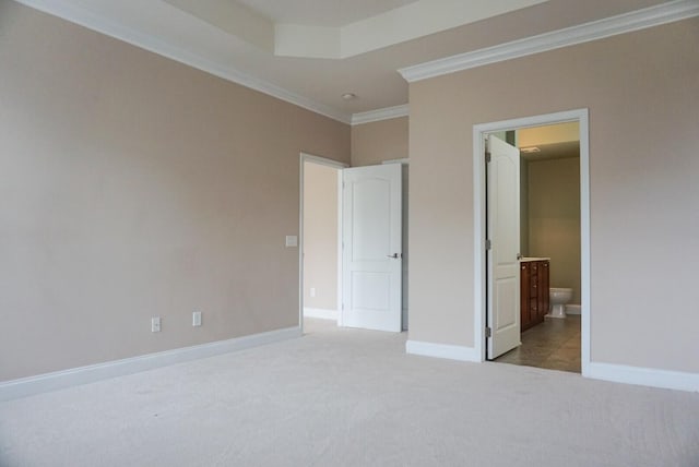 unfurnished bedroom with crown molding, light colored carpet, and ensuite bathroom