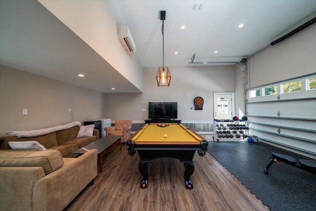 rec room with wood-type flooring, a towering ceiling, a wall mounted air conditioner, and pool table