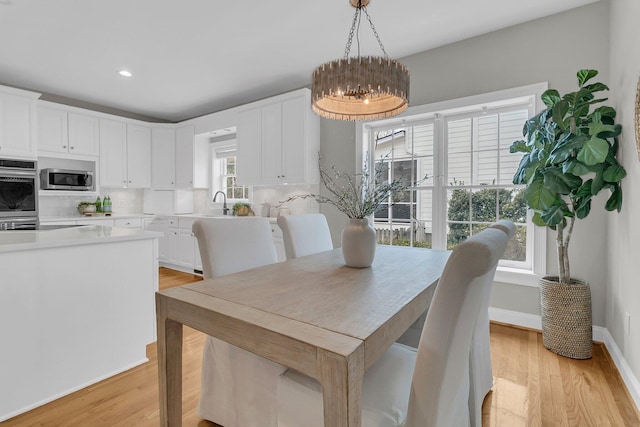 dining room featuring plenty of natural light, light hardwood / wood-style floors, and a chandelier