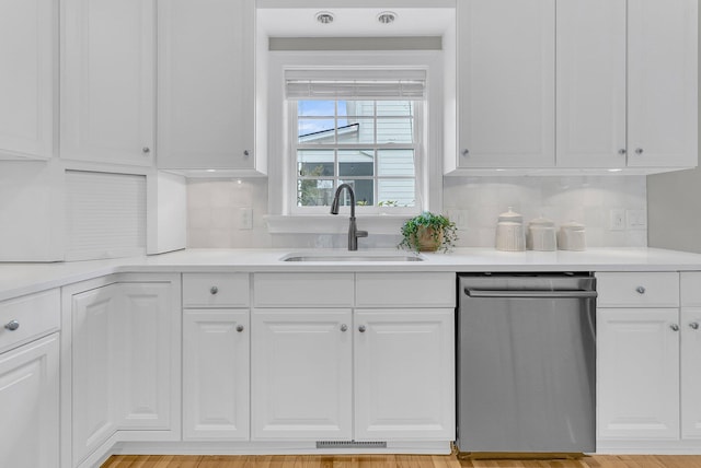 kitchen with sink, white cabinets, and dishwasher