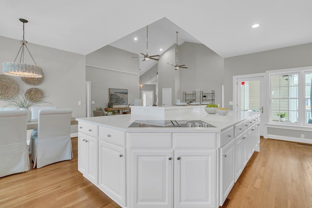 kitchen with white cabinetry, a kitchen island, and black electric stovetop