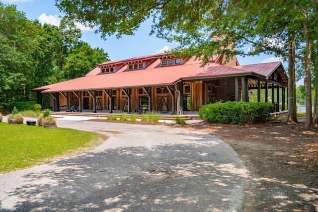 view of front of house with metal roof, a porch, and driveway
