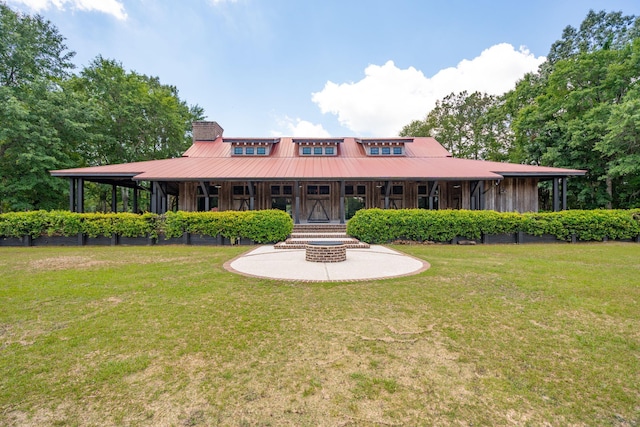 view of front of house with a front yard, metal roof, and a chimney