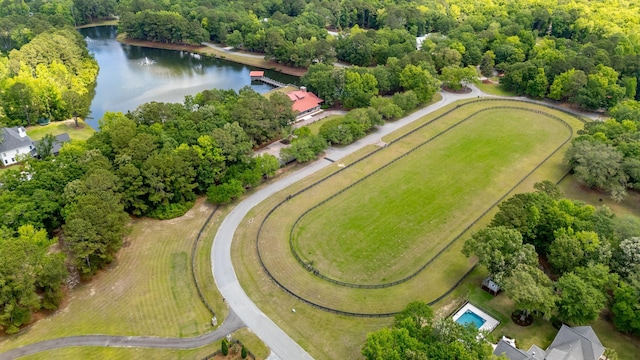 aerial overview of property's location featuring a nearby body of water and a heavily wooded area