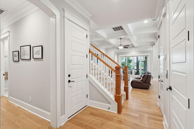 foyer with a ceiling fan, light wood-style flooring, beamed ceiling, stairs, and arched walkways
