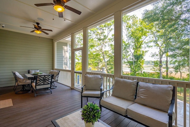 sunroom / solarium featuring outdoor dining area, ceiling fan, and an outdoor hangout area