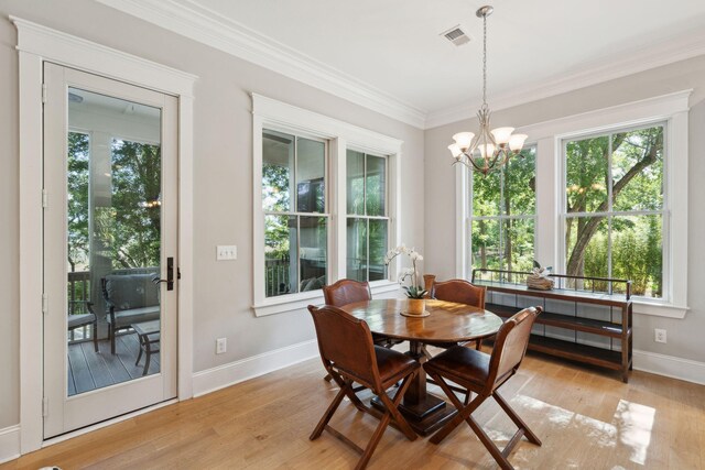 dining room featuring plenty of natural light, baseboards, a chandelier, light wood-style flooring, and crown molding