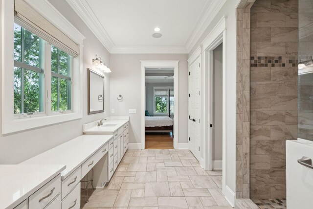 ensuite bathroom with walk in shower, vanity, crown molding, recessed lighting, and baseboards