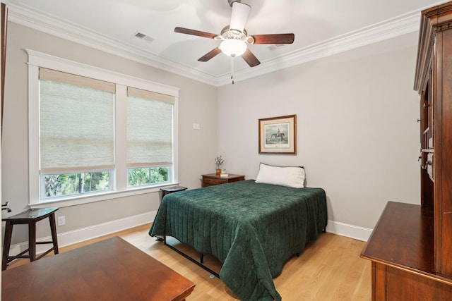 bedroom with crown molding, light wood finished floors, baseboards, and ceiling fan