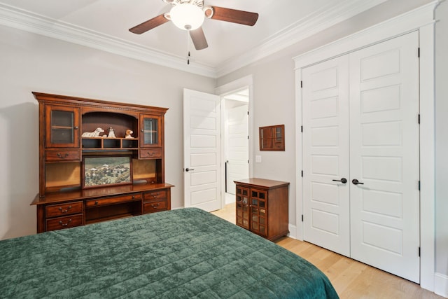 bedroom featuring a closet, ornamental molding, light wood-style flooring, and ceiling fan
