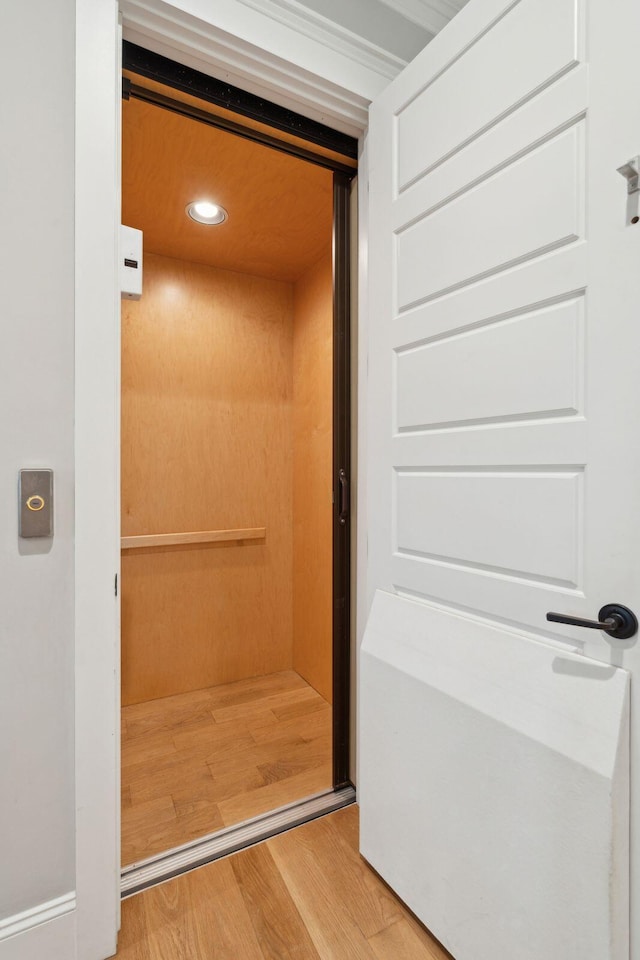 elevator featuring wood finished floors and recessed lighting