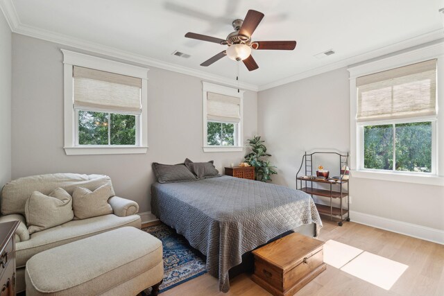 bedroom with light wood-style flooring, crown molding, baseboards, and ceiling fan