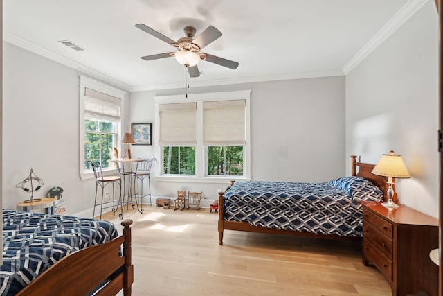 bedroom with light wood-style flooring, ornamental molding, and a ceiling fan