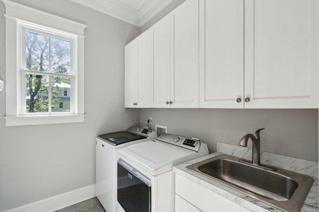 clothes washing area with cabinet space, washer and dryer, crown molding, and baseboards