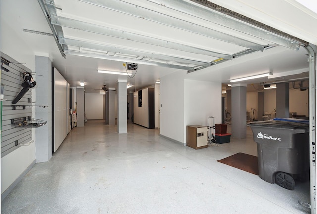 garage with a garage door opener, baseboards, and a ceiling fan