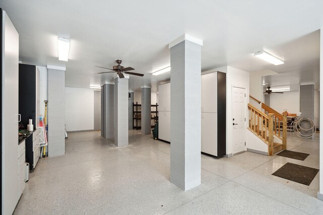 below grade area with a ceiling fan and stairs