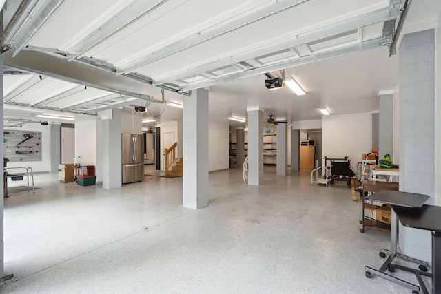 garage with freestanding refrigerator and a garage door opener